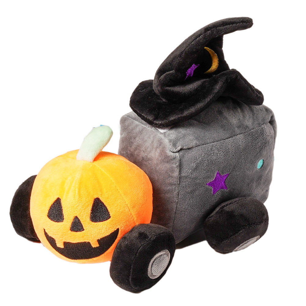 ouet pour chien en peluche thème PapattesBox Halloween Magic Train — une citrouille orange souriante attachée à un wagon gris en forme de cube décoré d’étoiles violettes et d’un chapeau de sorcière.